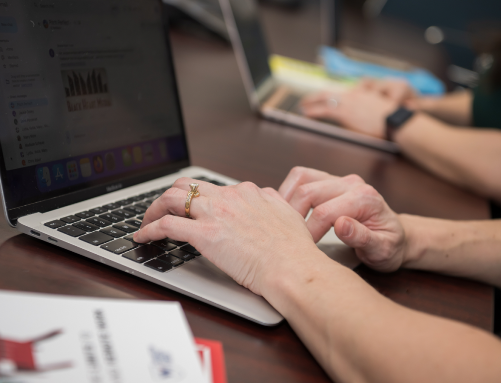 Hands typing on a laptop during a consultation